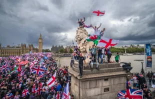 Manifestantes agitam bandeiras da Union Jack e da Cruz de São Jorge no protesto Unite the Kingdom na ponte de Westminster, perto do parlamento britâncio, em  Londres, em 13 de setembro de 2025.