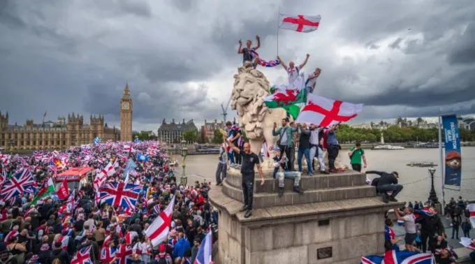 Manifestantes agitam bandeiras da Union Jack e da Cruz de São Jorge no protesto Unite the Kingdom na ponte de Westminster em 13 de setembro de 2025 ?? 