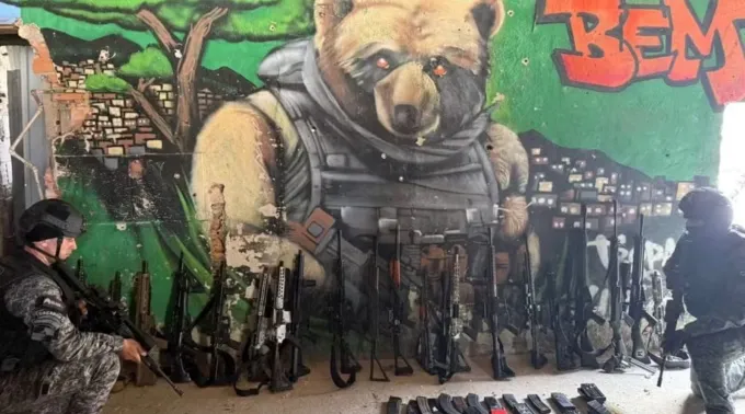 Policiais com parte da apreensão de fuzis da Operação Contenção