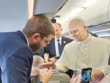 O papa Leão XIV abençoando rosários hoje (27) para Elias Turk, da EWTN News, a bordo do avião papal rumo a Ancara, Turquia.