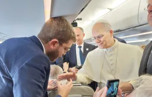 O papa Leão XIV abençoando rosários hoje (27) para Elias Turk, da EWTN News, a bordo do avião papal rumo a Ancara, Turquia.