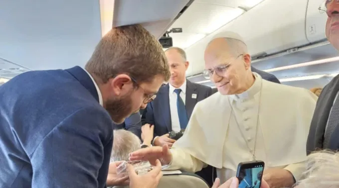 Leão XIV abençoa rosários para Elias Turk, da EWTN News, a bordo do avião papal rumo a Ancara, Turquia, em 27 de novembro de 2025 ?? 