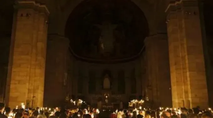 Fiéis seguram velas na missa da vigília Pascal na basílica do Sagrado Coração em Paris, França, em abril de 2025 ?? 