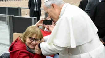 Papa Leão XIV cumprimenta mulher na Aula Paulo VI, no Vaticano.