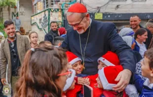 Crianças cumprimentam o patriarca latino de Jerusalém, cardeal Pierbattista Pizzaballa, em sua visita à paróquia da Sagrada Família, em Gaza, na última sexta-feira (19).