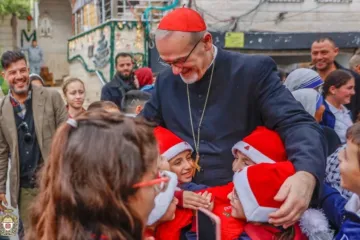 Crianças cumprimentam o patriarca latino de Jerusalém, cardeal Pierbattista Pizzaballa, em sua visita à paróquia da Sagrada Família, em Gaza, em 19 de dezembro de 2025