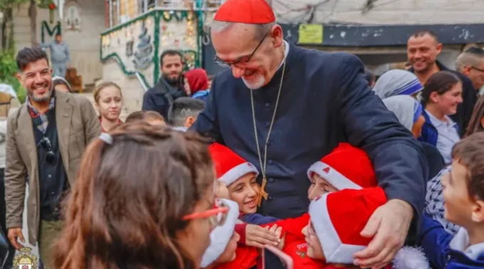 Crianças cumprimentam o patriarca latino de Jerusalém, cardeal Pierbattista Pizzaballa, em sua visita à paróquia da Sagrada Família, em Gaza, em 19 de dezembro de 2025 ?? 