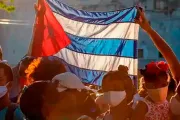 Pessoas com bandeira de Cuba. Imagem meramente ilustrativa.