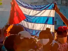 Pessoas com bandeira de Cuba. Imagem meramente ilustrativa.