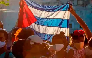 Pessoas com bandeira de Cuba. Imagem meramente ilustrativa.