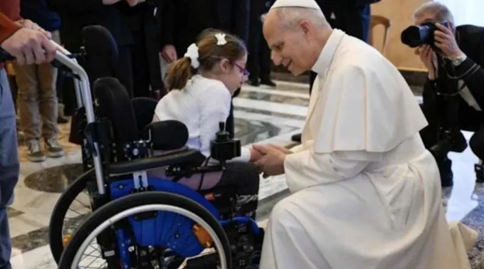 Papa Leão XIV cumprimenta menina em cadeira de rodas em audiência com membros da Ação Católica Italiana no Vaticano, em 19 de dezembro de 2025 ?? 