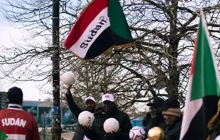 Pessoas com bandeiras do Sudão. Imagem referencial.