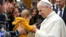 Bebê brinca com a cruz peitoral do papa Leão XIV em audiência geral.