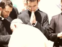 O papa Francisco beija as mãos de um grupo de sacerdotes recém-ordenados