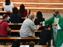 Sacerdote dá a Comunhão durante uma missa na paróquia de são Fernando de Dilao, em Paco, Manila, no dia 25 de julho de 2021. Crédito: Cortesia de Paco Church para CBCP.