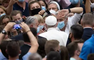 Pessoas usando máscaras cumprimentam o Papa Francisco