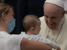 Papa Francisco com uma criança e a mãe dela
