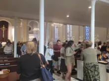Multidões saem da Igreja Católica da Santíssima Trindade em Washington, DC, após a "Missa do Orgulho" de 14 de junho de 2023, com bandeiras LGBT visíveis na igreja. -  Pedro Pinedo