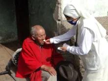 Religiosa visitando um homem idoso no Equador em maio de 2020. Crédito: ACN