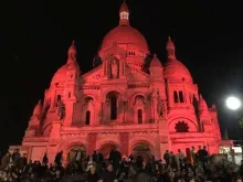 Basílica do Sagrado Coração em Paris iluminada de vermelho 