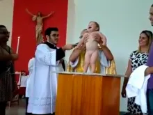 O pequeno Gustavo durante o batizado.
