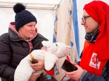 Voluntária da Cáritas Polônia atende mãe e bebê ucranianos