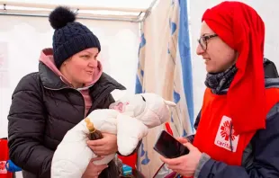 Voluntária da Cáritas Polônia atende mãe e bebê ucranianos