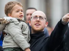 Pai participa com o seu filho da oração do Ângelus na Praça de São Pedro, no Vaticano.
