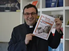 Pe. Andrea Ciucci mostra um folheto do encontro que o Papa terá com os idosos no dia 28 de setembro