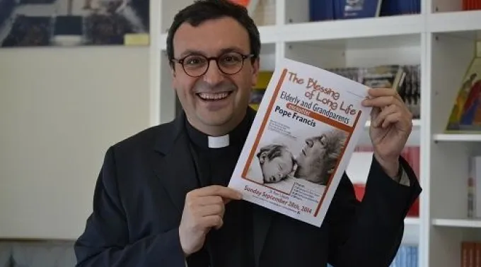 Fr_Andrea_Ciucci_holds_a_flyer_for_the_Popes_Sept_28_audience_with_elderly_and_grandparents_on_July_11_2014_Credit_Daniel_Ibanez_CNA_CNA.jpg ?? 