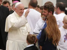Papa Francisco saudando uma família.