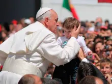Papa Francisco abençoa uma criança na Praça de São Pedro.