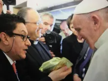 O jornalista Néstor Ponguta entrega uma bolsa de café ao Papa no voo que o leva a Cuba.