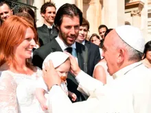 Papa saúda uma família no Vaticano.