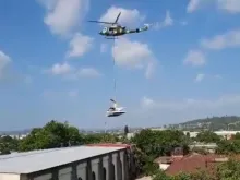 Um helicóptero das forças armadas remove o helicóptero da polícia que caiu sobre a Igreja de La Merced