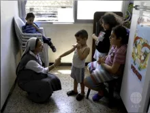 Irmã Annie Demerijan, colaboradora de Ajuda à Igreja que Sofre na Síria, junto com crianças cristãs em Aleppo.