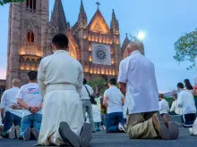 Homens rezam em frente à Catedral de Guadalajara