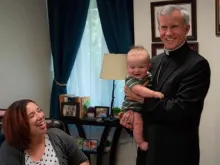 Deanna Johnston, diretora de vida familiar do Instituto São Felipe, observa como Dom Joseph Strickland segura seu bebê