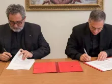 Da esquerda para a direita) Pe. Juan Antonio Guerrero Alves e Mons. Dario Edoardo Viganò assinando o acordo