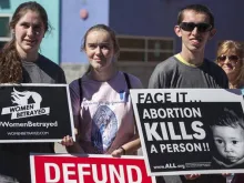 “Mulheres traídas” e “o aborto mata uma pessoa” pode-se ler nos cartazes destes jovens pró-vida.