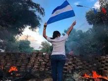 Uma mulher com a bandeira da Nicarágua em uma barricada durante os protestos de abril de 2018,