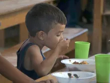 Criança migrante almoçando no Lar “Divina Providencia”, em Cúcuta.