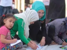 Crianças cristãs e muçulmanas fazendo desenhos pela paz em Alepo 