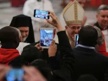 Papa em uma celebração rodeado por celulares.