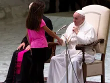 Papa cumprimenta menina que interrompeu seu discurso.