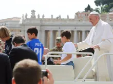 O Papa no papamóvel com algumas crianças.