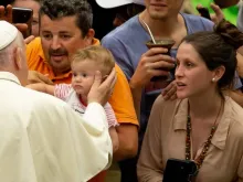 Papa abençoa uma criança ao chegar à Sala Paulo VI.