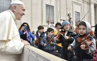 Papa observa algumas crianças tocando instrumentos musicais.
