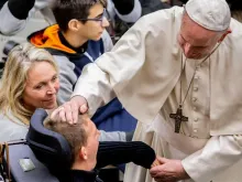 Papa Francisco abençoa uma pessoa com deficiência.