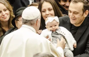 Papa abençoa uma menina na audiência.